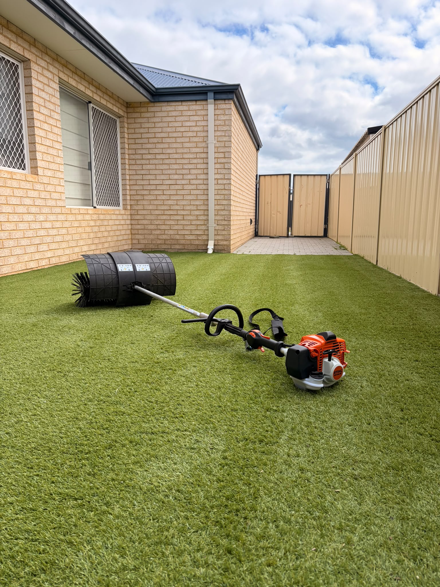 Wide view of the same cleaned Perth backyard lawn from the side gate, even green fibres from the house to the fence line